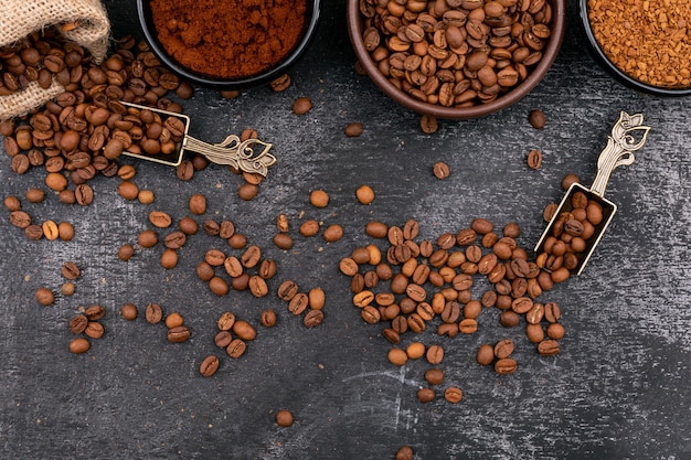 Free Photo the coffee beans in bowls metal spoon and sackcloth on dark surface