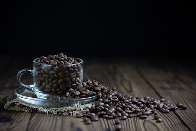 Coffee beans in cup on table