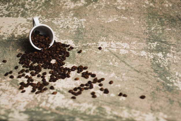 Free photo coffee beans spilled from cup