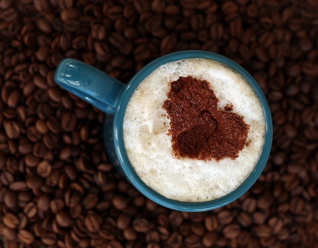 Free photo coffee beans with mug in the middle