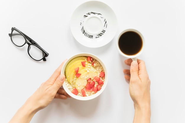 Coffee and bowl with fruits and cereals