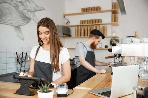 Free photo coffee business concept beautiful caucasian bartender barista or manager posting order in digital tablet menu at modern coffee shop