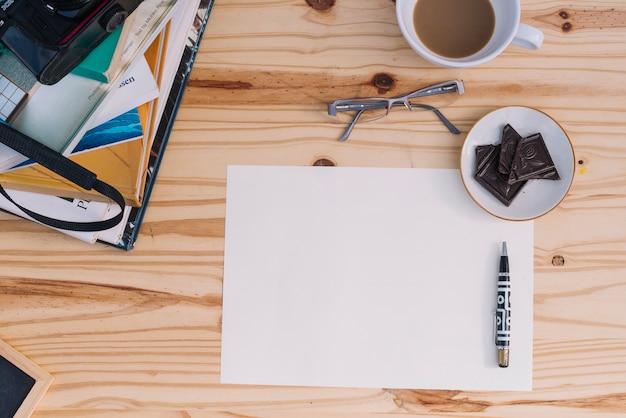 Coffee and chocolate near paper sheet