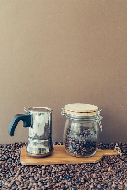 Free photo coffee composition with moka pot and jar on board