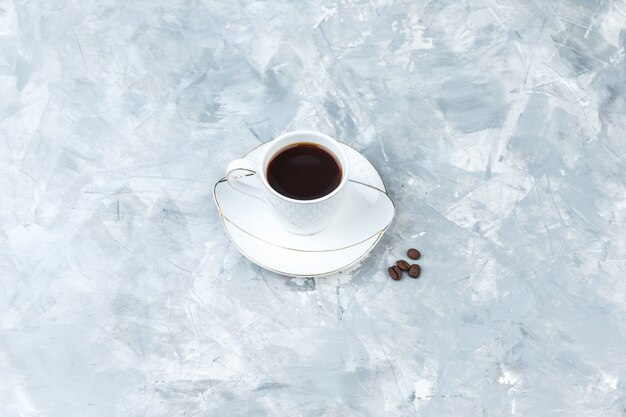 Coffee in a cup on a blue marble background. high angle view.