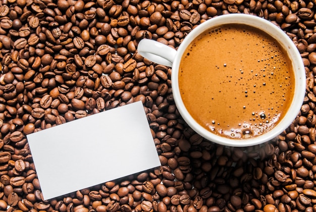 Coffee cup and coffee beans on table, top view, love coffee, Brown coffee beans isolated on white background, Hot Coffee cup with Coffee beans