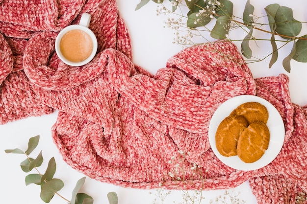 Free Photo coffee cup and cookies on scarf decorated with leaves and flowers on white background