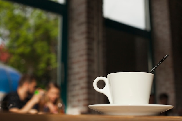 Free photo coffee cup on table over defocused cafeteria background