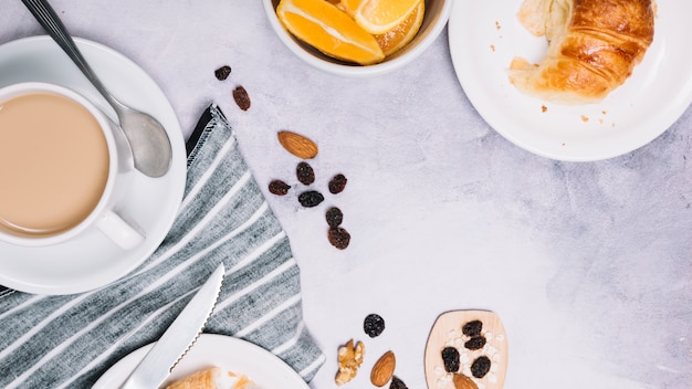 Coffee cup with croissant on plate