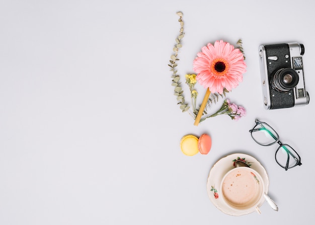 Coffee cup with flower bud, camera and glasses 