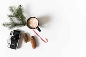 Free photo coffee cup with green fir tree branch on table