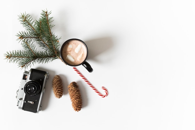 Coffee cup with green fir tree branch on table