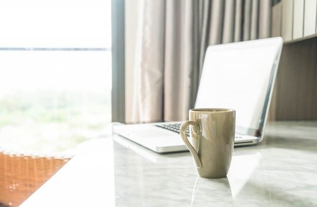 Free photo coffee cup with laptop and beautiful luxury table decoration in livingroom interior for background