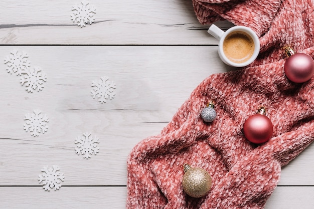 Coffee cup with shiny baubles on table 