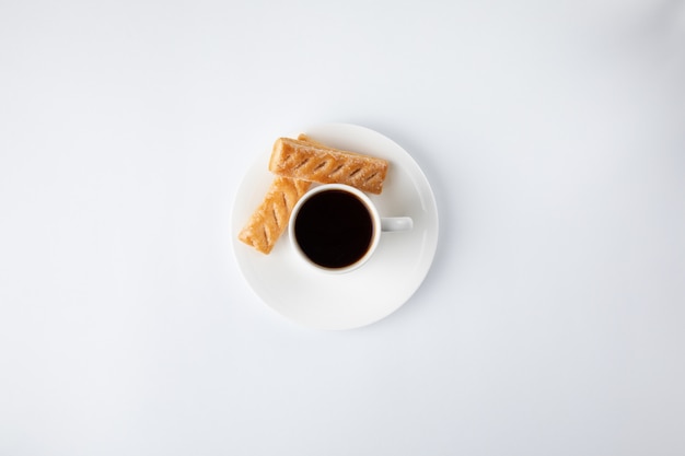 Coffee cup with sweets isolated on white