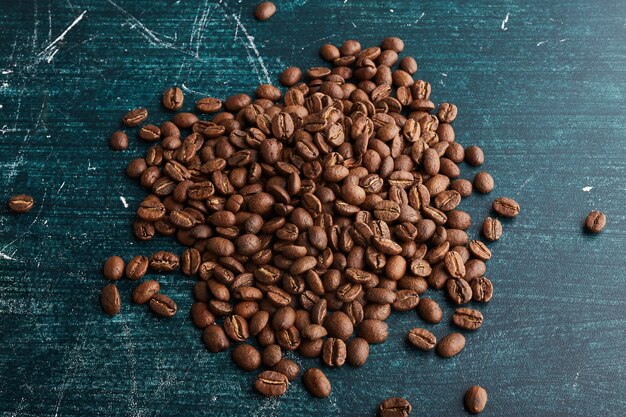 Coffee grains on blue surface. 