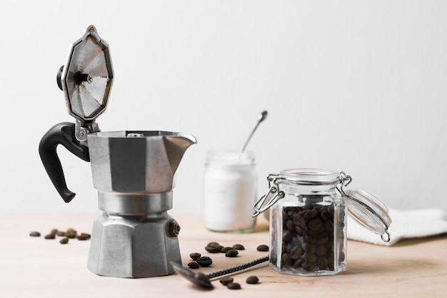 Free Photo coffee grinder and beans of coffee front view