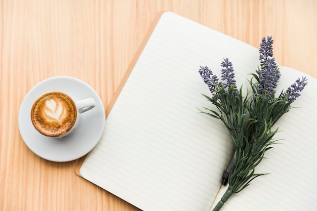 Free photo coffee latte,lavender flower and notebook on wooden desk