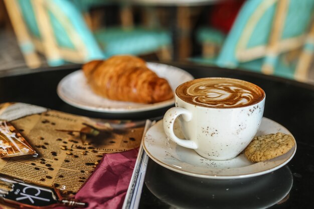 Coffee latter with cookies croissant side view