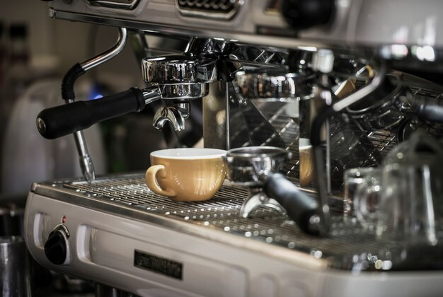 Coffee machine with coffee cup at cafe