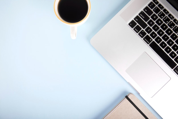 Coffee and notebook near laptop