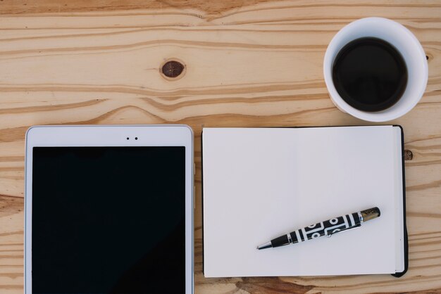 Coffee and notebook near tablet