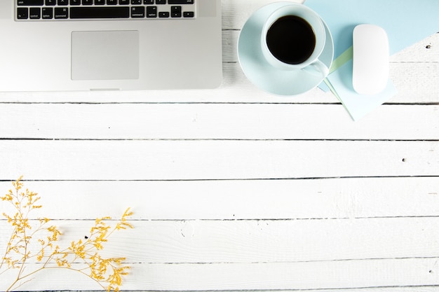 Coffee and twig near laptop on table