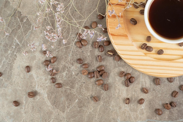 Coffee on wooden plate with coffee beans