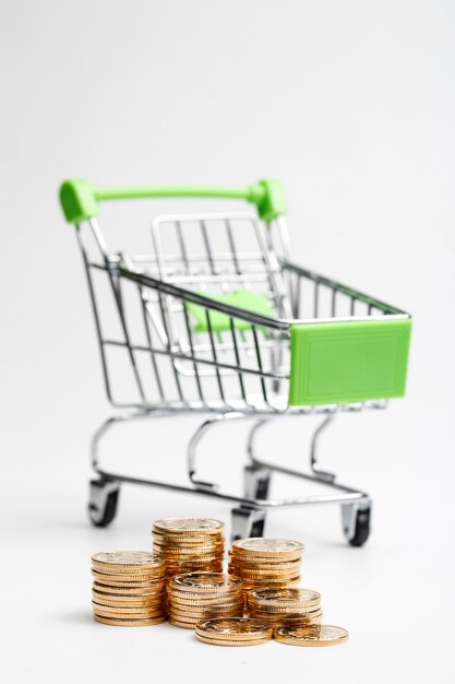 COINS pile and shopping cart on a white background