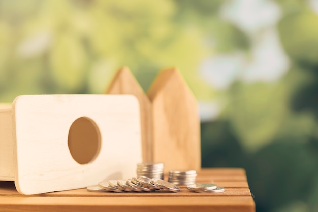 Free Photo coins spilling from wooden piggybank on table