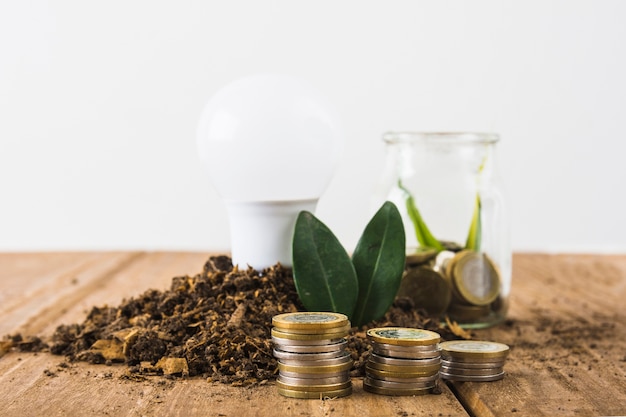 Free photo coins stack with light bulb and jar