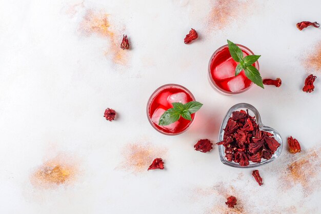 Cold brew hibiscus tea with ice and basil leaves.