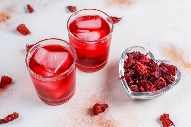 Cold brew hibiscus tea with ice and basil leaves.