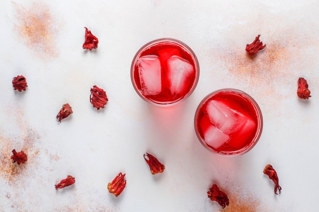 Cold brew hibiscus tea with ice and basil leaves.