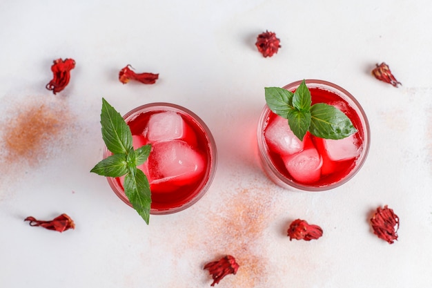 Free photo cold brew hibiscus tea with ice and basil leaves.