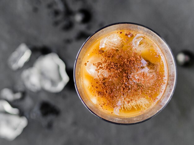 Cold orange cocktail with ice and cinnamon