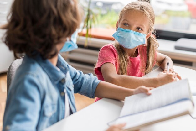 Colleagues doing their homework while wearing a medical mask