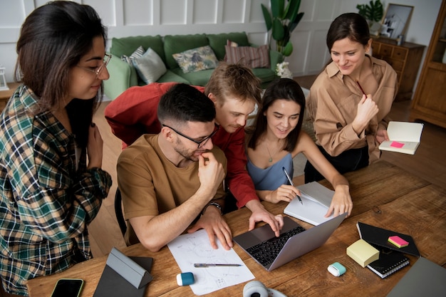 Free photo colleagues looking for information using a laptop and notebooks in a study session