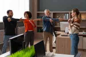 Free photo colleagues at the office stretching during a work day