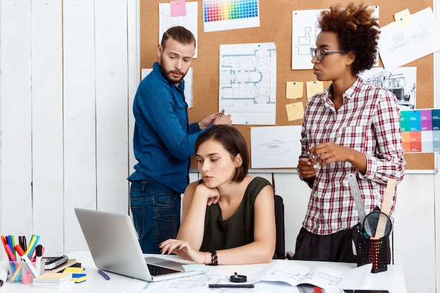 Colleagues speaking,  discussing drawings, new ideas in office