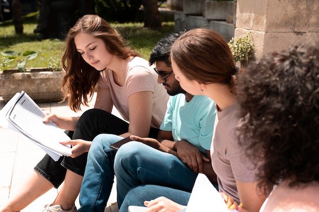 Free photo colleagues studying together in front of their college before an exam