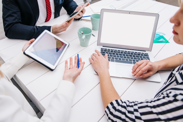 Colleagues with devices at working desk