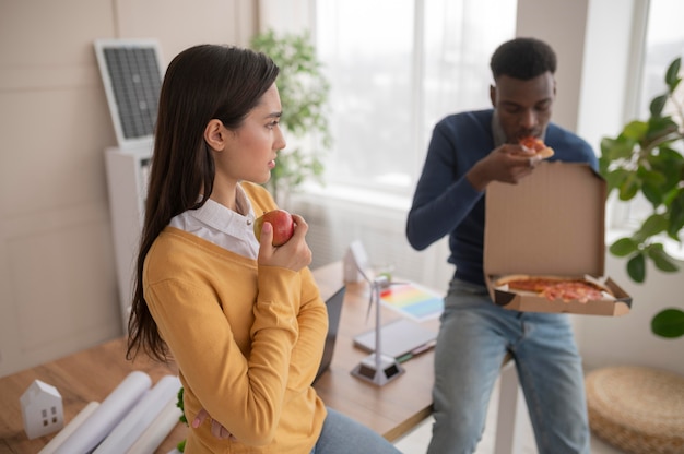 Colleagues at work eating pizza