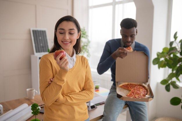 Colleagues at work eating pizza