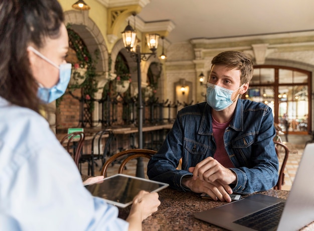 Free photo colleagues working together indoors while wearing medical masks