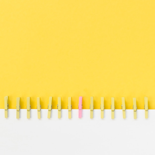 Collection of clothespins next to a pink one