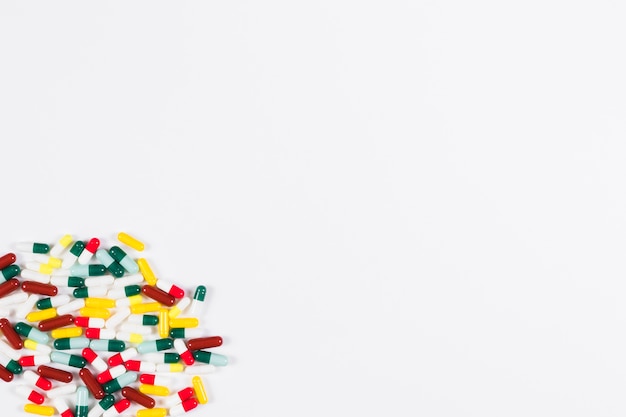 Free Photo collection of colorful capsules in the corner of white backdrop