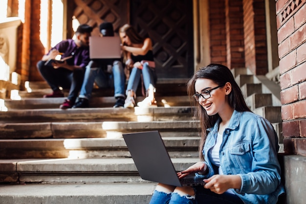 College girl working with laptop after lessons