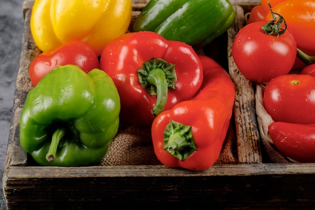 Color bell peppers in the wooden container.