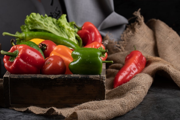 Free photo color peppers and greenery in a rustic tray.